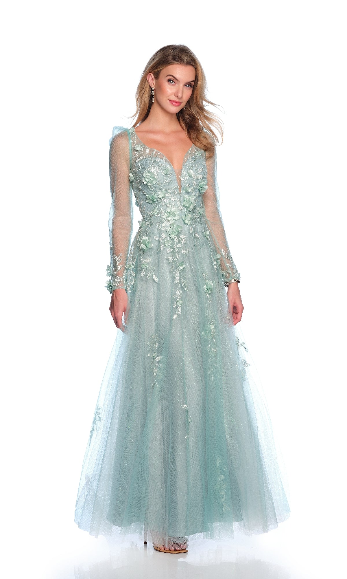 A woman wears the Dave & Johnny 12127 formal dress with sleeves—a long, light blue gown featuring sheer long sleeves and floral appliqué—standing against a plain white background.